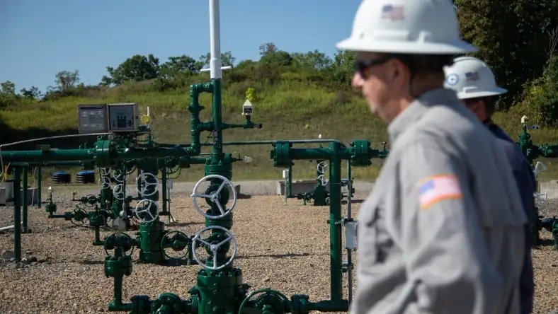 Biogas facility piping and control valves with workers on site