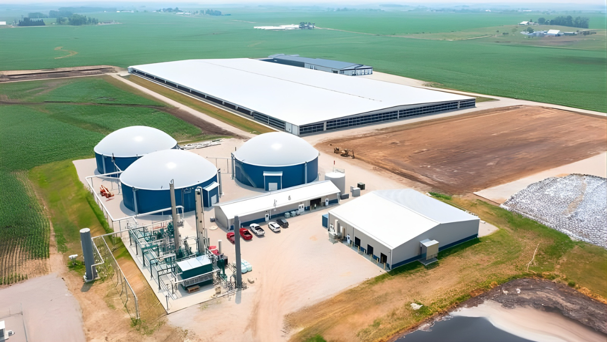 Aerial view of biogas production facility with digesters and processing units on farmland