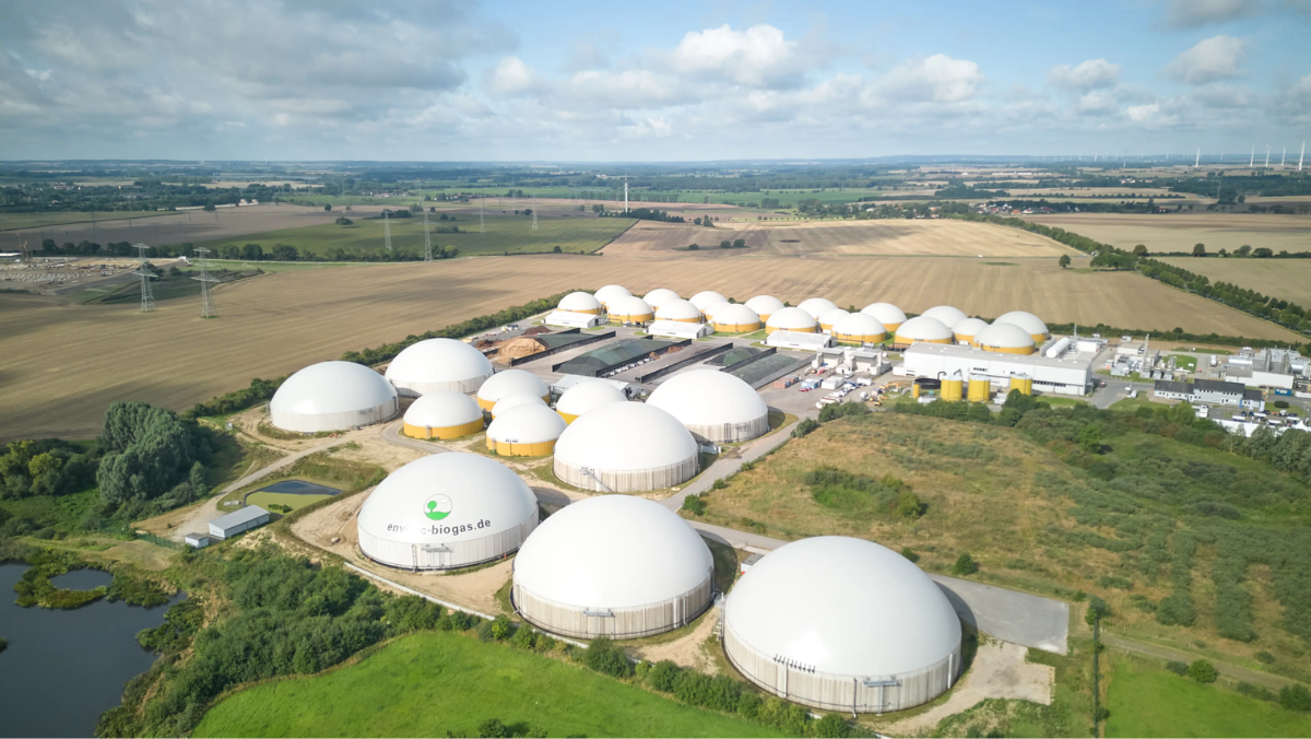 Aerial view of large biogas plant with multiple dome digesters in rural landscape